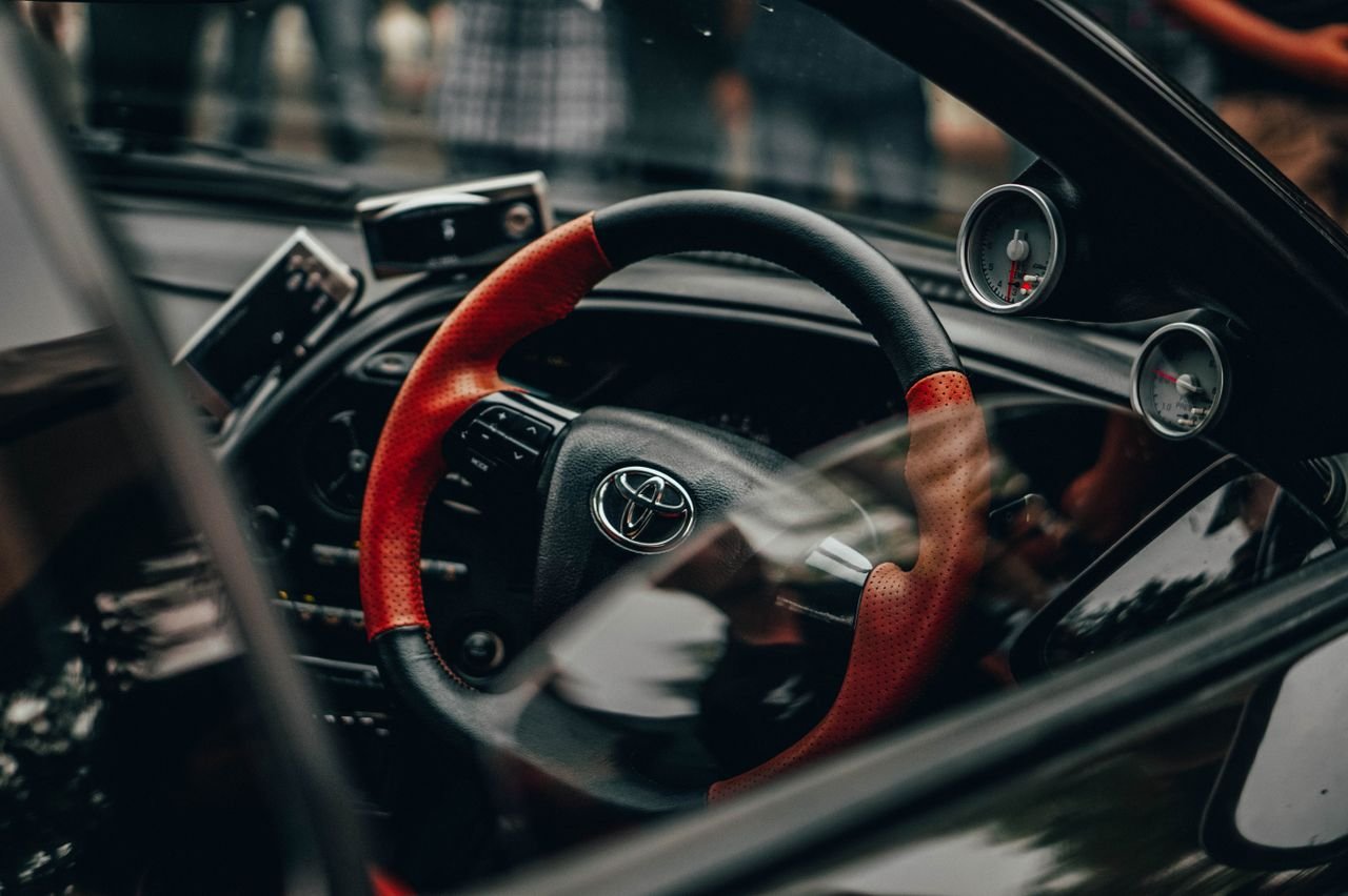 Close-up of a Toyota steering wheel inside a stylish car, emphasizing modern design.